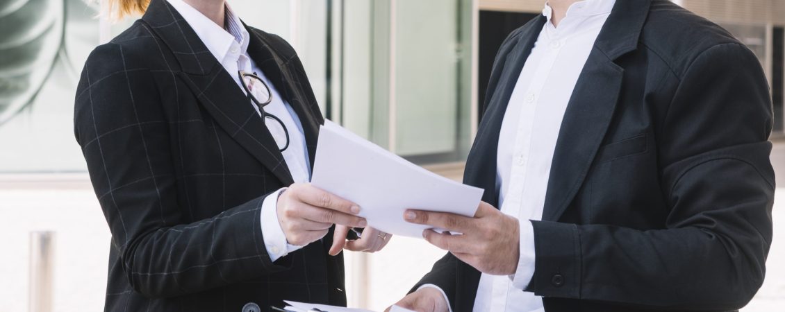 businessman-and-businesswoman-holding-documents-in-hands