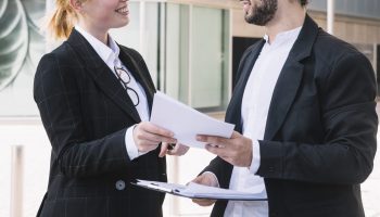 businessman-and-businesswoman-holding-documents-in-hands