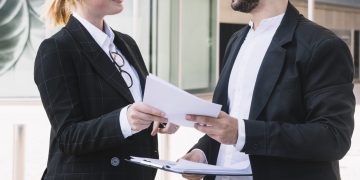 businessman-and-businesswoman-holding-documents-in-hands
