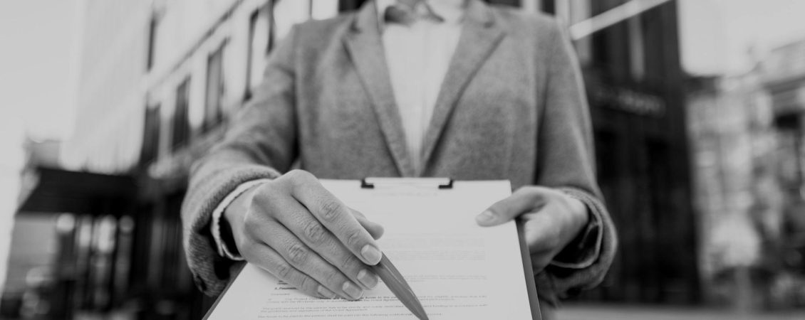 smiley-businesswoman-showing-you-where-to-sign-on-clipboard-darken